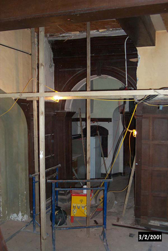 A modern fa&ccedil;ade being removed to reveal the original entrance to the Servants' Passage